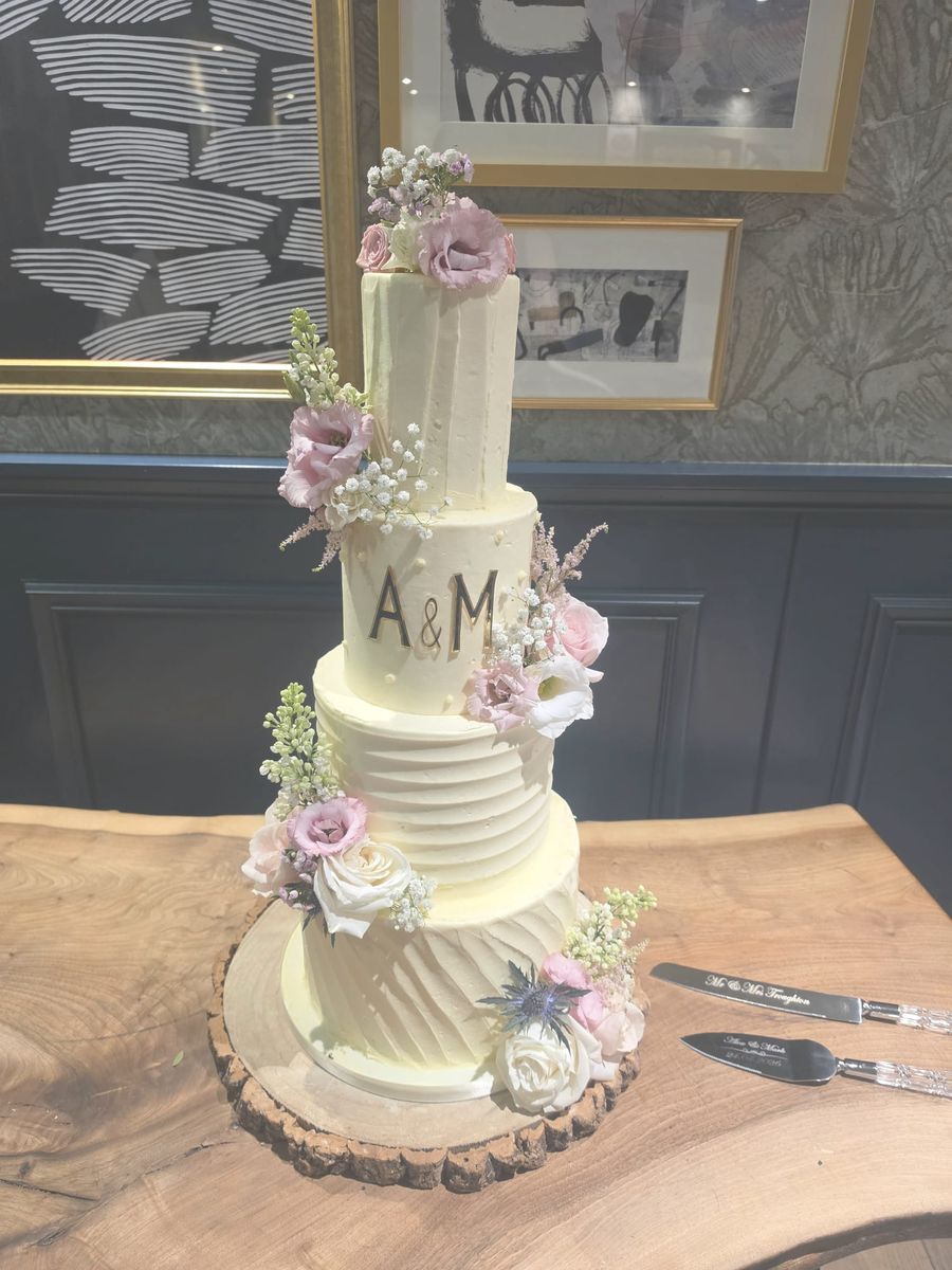 Four tier buttercream wedding cake with fresh flowers