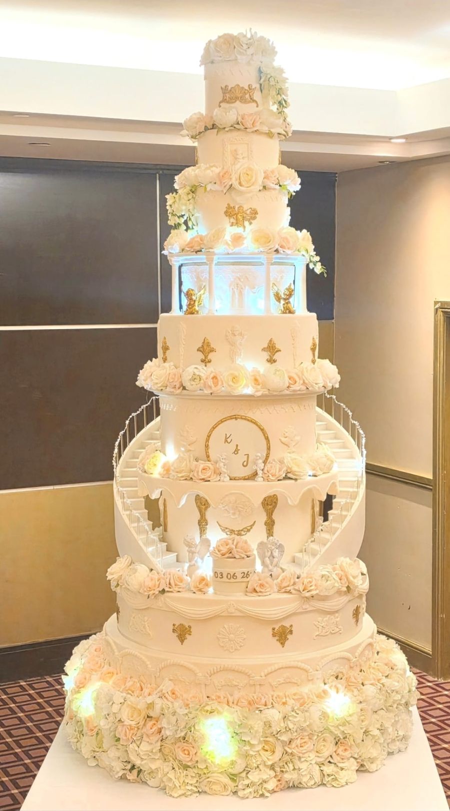 Castle style wedding cake with curved staircases, lights and gold detail