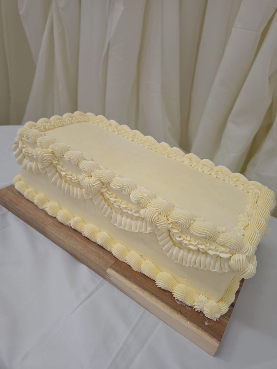 Long buttercream table cake with vintage piped swags