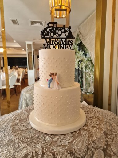 Elegant three-tier wedding cake with a bride and groom topper.